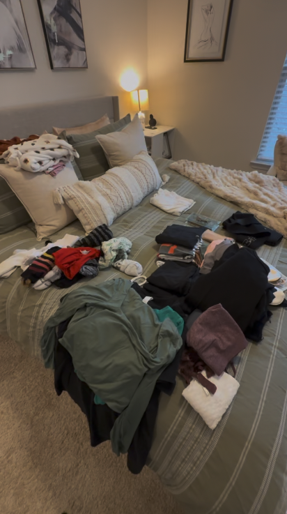 A bedroom with laundry piled across the bed.